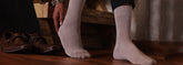 Formal men’s socks in dark solid colour with subtle pattern, styled in professional setting.